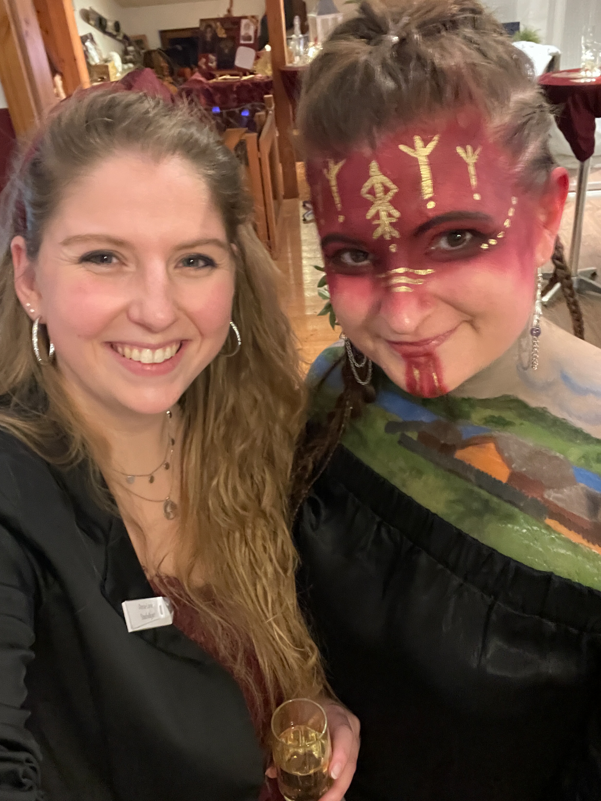 Zwei Mädchen, eine bemalt mit Facepainting von Haitabu, lachen in die Kamera.