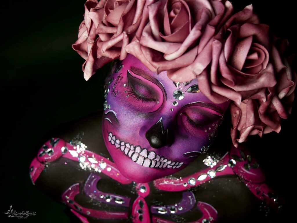 aufwendiges Fachepainting als Sugar Skull in rosa und lila mit vielen Steinen.